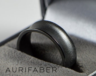 May include: A black brushed metal ring in a gray velvet ring box with the text "Aurifaber" on the box.