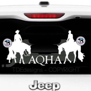 以下が含まれることがあります： 黒い背景に、馬に乗った2人のライダーの白いシルエットと、「AQHA」と「TDEdesigns - COPYRIGHT」の文字が書かれています。画像には、「The Divine Equine」と「Since 2008」の文字が書かれた円形のロゴも2つ含まれています。
