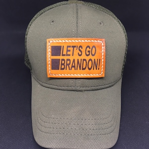 May include: A green mesh trucker hat with a brown leather patch that says "Let's Go Brandon!"