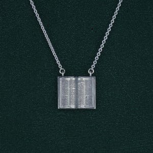Pequeño collar de libro antiguo abierto, grimorio o códice manuscrito, finos detalles con iniciales, joyería para bibliófilos en plata 925 patinada