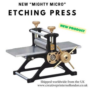 Op de afbeelding: Een zwart-gouden etspers met een zilveren rol en tafel. De tekst "NEW 'MIGHTY MICRO' ETCHING PRESS" staat bovenaan. Een gele sticker leest "NEW PRODUCT".