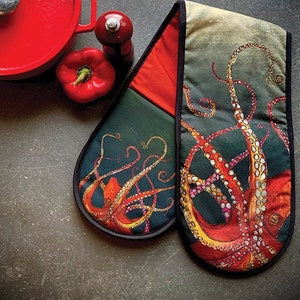 May include: A pair of red and black oven mitts featuring an octopus design. The octopus is orange, yellow, and white with black outlines. The mitts are made of fabric and have a quilted texture.