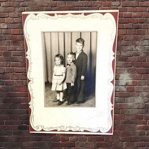 Foto familiar vintage enmarcada en cartón plegable, retrato, niños y niñas, 18 x 25 cm, en blanco y negro, hermanos, década de 1950.