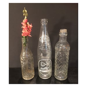 Old glass soda bottles,clear,set of 3,decorative,early 1900s,ornate,beverages,collectible,9&quot; tall,embossed,foggy,liquor,white lettering