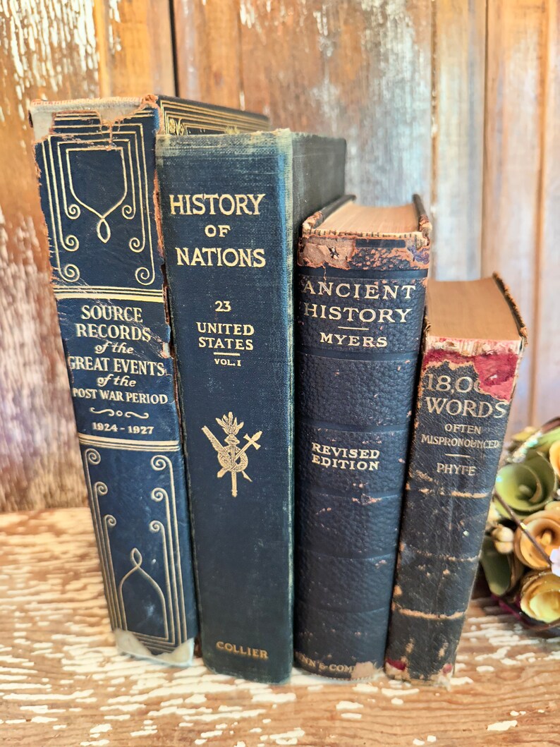 Puede incluir: Cuatro libros antiguos de tapa dura con cubiertas negras y letras doradas. Los t&iacute;tulos son "Source Records of the Great Events of the Post War Period 1924-1927", "History of Nations 23 United States Vol. I", "Ancient History Myers Revised Edition", y "1800 Words Often Mispronounced Phyfe".
