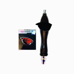 May include: Black and silver beer tap handle with a red and orange beaver logo on a white background. The text "TEAM EMBLEM ALUMINUM COLOR" is on the box.