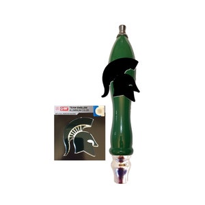 May include: Green beer tap handle with a black Spartan helmet emblem. The handle has a silver top and bottom. A separate sticker with a gold Spartan helmet emblem is included. The sticker says "Team Emblem Aluminum Color with full adhesive backing."
