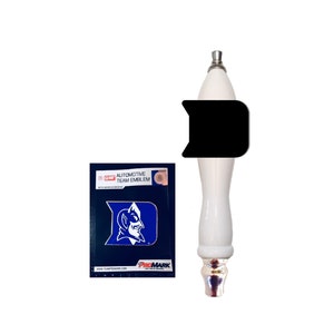 Könnte beinhalten: Ein weißer Zapfhahn mit schwarzem Akzent und silbernen Details. Neben dem Zapfhahn befindet sich ein blau-weißes Automobil-Team-Emblem mit einem Teufelslogo. Das Emblem trägt den Text "AUTOMOTIVE TEAM EMBLEM".