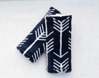 A pair of navy blue arrow reversible baby car seat strap - stroller strap cover