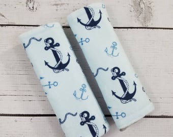 Könnte beinhalten: Zwei hellblaue Stoff-Sicherheitsgurt-Abdeckungen mit einem dunkelblauen Anker- und Seildesign.