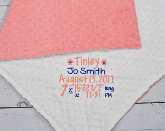 May include: A white and pink baby blanket with embroidered text: "Tinley Jo Smith August 13, 2017 7 lbs 15 oz 22 1/2" long 11:31 PM"