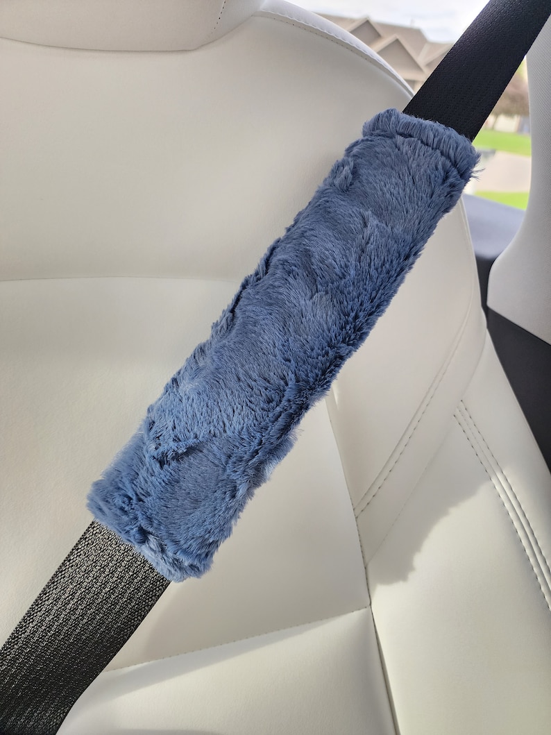 Puede incluir: Un coj&iacute;n de hombro para cintur&oacute;n de seguridad de felpa azul. El coj&iacute;n est&aacute; hecho de un material suave y peludo y est&aacute; dise&ntilde;ado para brindar comodidad y apoyo mientras se conduce.