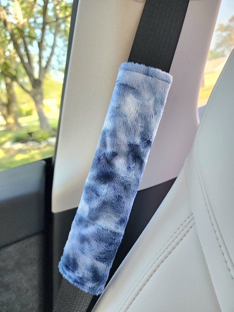 Puede incluir: Una funda de cintur&oacute;n de seguridad de coche de felpa azul y blanco tie-dye. La funda est&aacute; hecha de un tejido suave y peludo y est&aacute; dise&ntilde;ada para proteger el cintur&oacute;n de seguridad del desgaste.