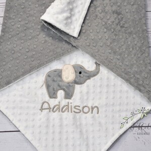 Puede incluir: Una manta de beb&eacute; gris y blanca con un elefante gris y el nombre Addison bordado en ella.