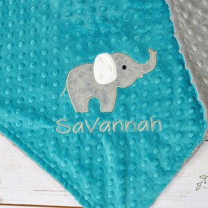 Puede incluir: Una manta de beb&eacute; de minky turquesa y gris con un elefante bordado gris y el nombre "Savannah" en ella.