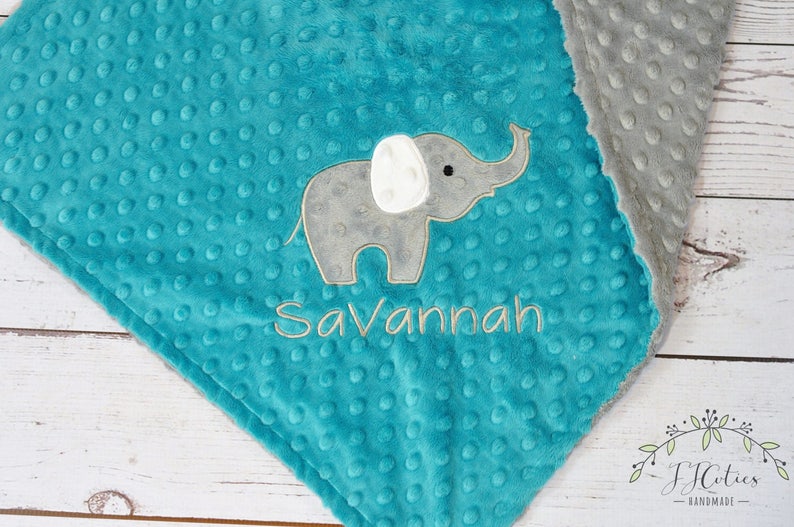 Puede incluir: Una manta de beb&eacute; de minky turquesa y gris con un elefante bordado gris y el nombre "Savannah" en ella.