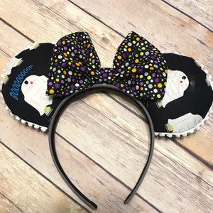 May include: Black and white mouse ears with a ghost and the text "BOOOOOOOP!" on one ear and a purple, green, and yellow polka dot bow on the headband.