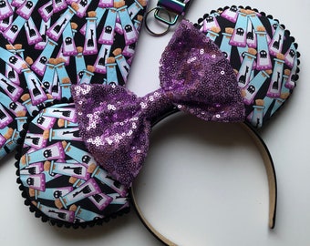May include: Purple sequin bow headband with black fabric ears featuring a pattern of potion bottles.