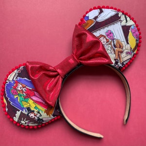 May include: Red Minnie Mouse ear headband with a large, shiny red bow. The ears feature a comic strip design with characters in red, pink, and purple. The ears are trimmed with red pom-poms, and the headband is black.
