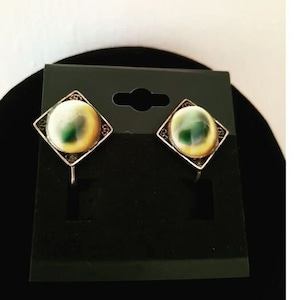 May include: A pair of silver clip-on earrings with a square design and a round, iridescent green and white stone in the centre.