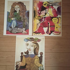 Peut inclure: Trois tirages d'art présentant des portraits abstraits colorés. L'un représente une figure assise aux longs cheveux, un autre une composition vibrante à plusieurs figures, et le troisième une femme avec un chapeau et des lunettes.