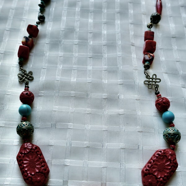 Bohemian style necklace, large cinnabar beads, brass and filigree charms, glass beads, square coral beads, turquoise beads.  Single strand.