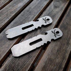 May include: Two silver metal multi-tools with a skull and crossbones design. Each tool has a bottle opener, a pry bar, and a flathead screwdriver.