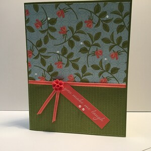 Carte d'occasion ornée d'un ruban, de fausses perles et d'une fleur de résine.