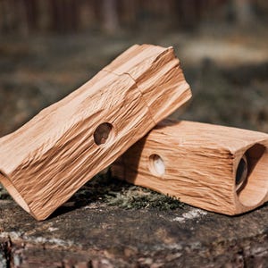 Peut inclure: Deux boîtes en bois avec une finition en bois naturel et un trou rond au centre de chaque boîte. Les boîtes sont empilées l'une sur l'autre.