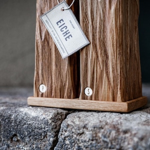 May include: Wooden salt and pepper shakers with a textured surface. The shakers are made of light brown wood and have a small tag that says "EICHE". The shakers are labeled with "P" and "S" on the front.