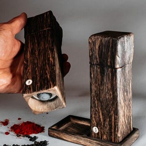 May include: Two wooden salt and pepper shakers with a dark brown finish. The shakers are labeled "S" and "P".