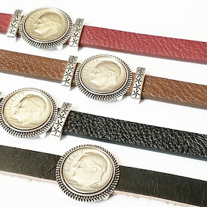 May include: Four leather bracelets with silver coin charms. The coins feature a profile of a man's face. The bracelets are in red, brown, black, and dark brown.