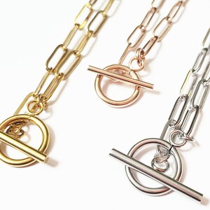 Puede incluir: Tres collares de oro, oro rosa y plata con cierres de palanca. Cada collar presenta una cadena hecha de eslabones ovalados unidos.