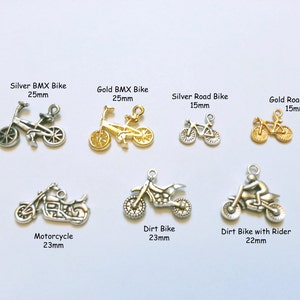 Könnte beinhalten: Sortiment an silbernen und goldenen Fahrrad-Anhängern, darunter BMX-Bikes, Rennräder, Dirtbikes und ein Motorrad. Die Anhänger sind etwa 15 mm bis 25 mm groß.