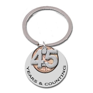 May include: Silver key chain with a silver charm that says "45 Years & Counting" and a copper penny with the number "45" on it.