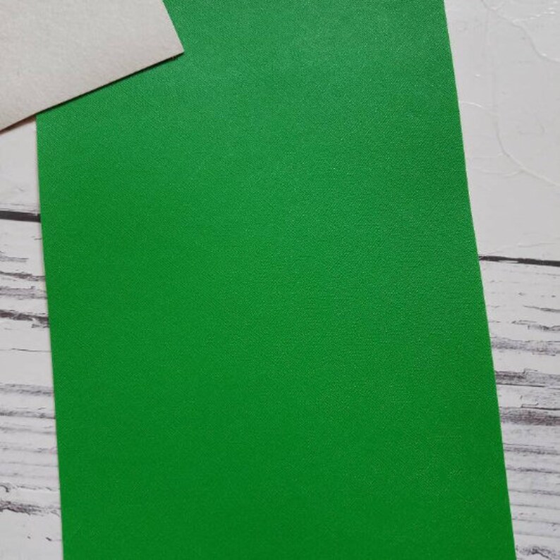 May include: A sheet of bright green craft paper with a slightly textured surface.