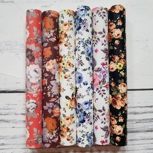 May include: Six rolls of floral patterned faux leather fabric. The patterns feature various shades of orange, brown, blue, and white.
