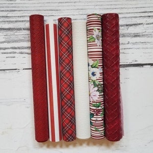 May include: Six rolls of red and white patterned faux leather. The patterns include plaid, stripes, and a floral design.
