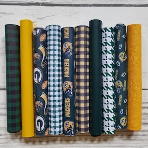May include: Nine different fabric swatches featuring the Green Bay Packers logo and team colors. The swatches include a variety of patterns, including plaid, houndstooth, and solid colors.