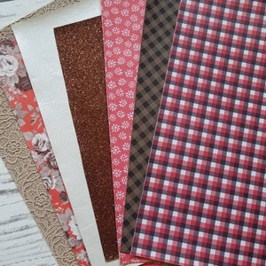May include: A set of six fabric swatches in various patterns and colors, including a beige lace, a white fabric, a brown glitter fabric, a red and white floral fabric, a brown and black plaid fabric, and a red and black gingham fabric.