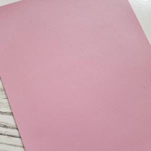 May include: A sheet of pale pink faux leather with a subtle textured pattern.