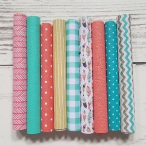 May include: Eight different patterned fabric strips in shades of coral, teal, and yellow. The patterns include chevron, polka dots, stripes, and a feather design.