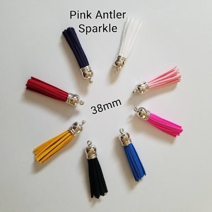 May include: Assortment of 10 colorful tassels with silver tops. The tassels are approximately 38mm long. The colors include red, pink, white, blue, yellow, black, and navy.