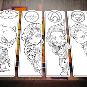May include: Four rectangular bookmarks featuring black and white line art illustrations of superhero characters. Each bookmark displays a circular logo at the top, including symbols for Batman, Wonder Woman, Aquaman, and Superman, with the characters below.