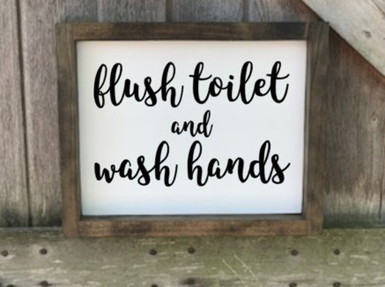 May include: A rustic wooden sign with the text "flush toilet and wash hands" in black cursive lettering on a white background.
