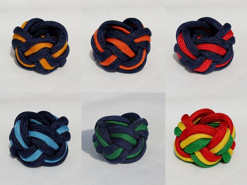May include: Six colorful, woven rope balls with a knot pattern. The balls are in various color combinations of blue, orange, red, and green.