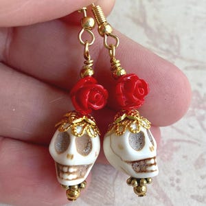 Pendientes de calavera del Día de los Muertos: calaveras de piedra, rosas y ganchos chapados en oro.
