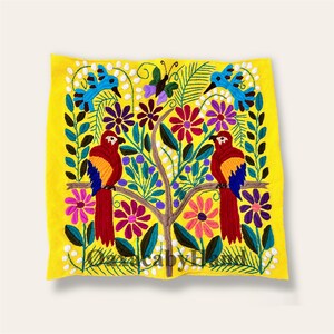 K&ouml;nnte beinhalten: Gelbes besticktes Textil mit einem Baum-Design. Es zeigt zwei rote Papageien, blaue V&ouml;gel und einen Schmetterling, umgeben von bunten Blumen und Bl&auml;ttern. Das Design ist handgestickt mit lebendigen F&auml;den.