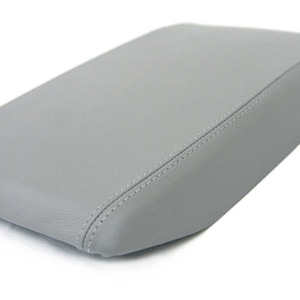 May include: Gray leather center console armrest cover with stitching.