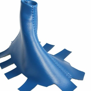 May include: Blue leather gear shift boot cover with a stitched seam and a pointed top.